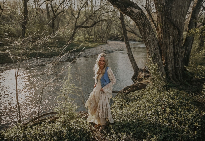 Summerlyn Powers stands on a riverbank in this promo photo