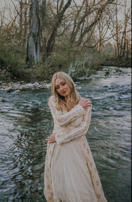 Summerlyn Powers stands in a river or creek in this promo photo
