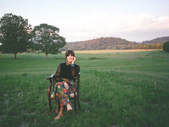 Lori Triplett seated on a chair in a grassy field