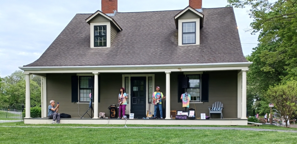 The Tokyo Tramps stand on the porch of the Gore Place farmhouse while performing during the 2025 Watertown Porchfest event